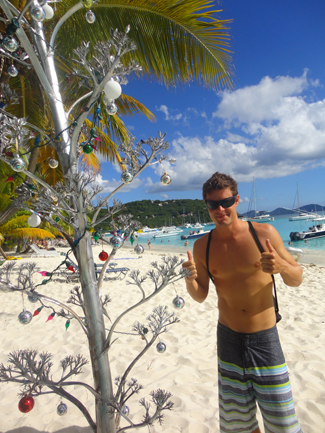 Jaman Spake on beach with palm tree.
